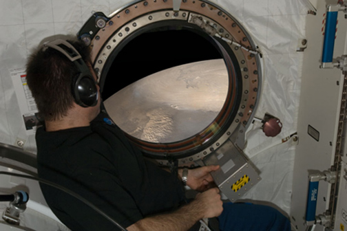 Will future Mars explorers see this scene before leaving their orbiting craft to land on the surface of the Red Planet?  (This simulated view from Mars orbit is based on an ISS image posted at Astronomy Picture of the Day on December 30, 2008.)